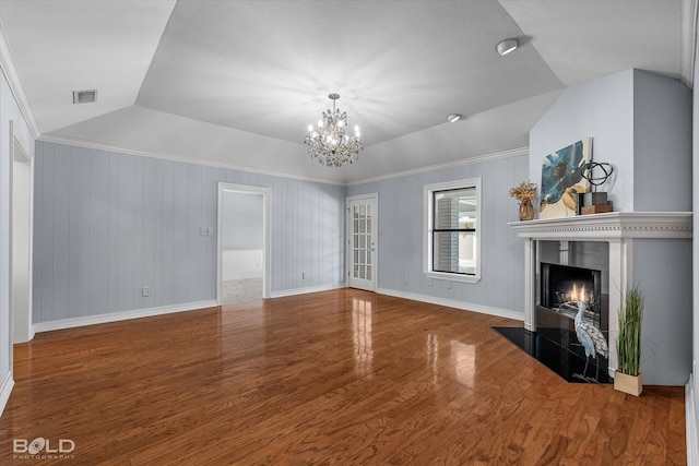 unfurnished living room featuring ornamental molding, lofted ceiling, hardwood / wood-style floors, and a notable chandelier