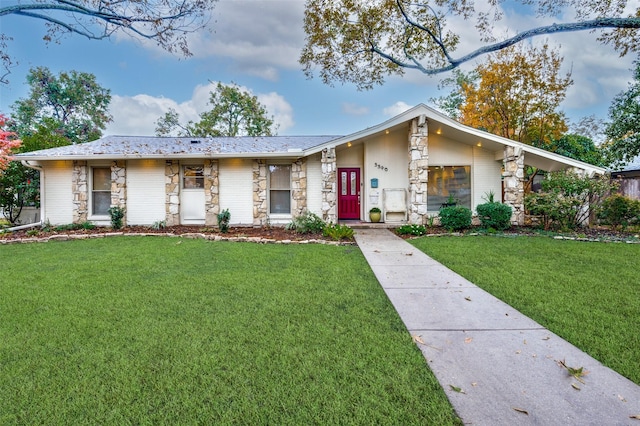 ranch-style home featuring a front lawn