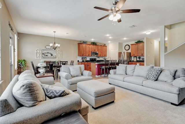 living room featuring ceiling fan with notable chandelier