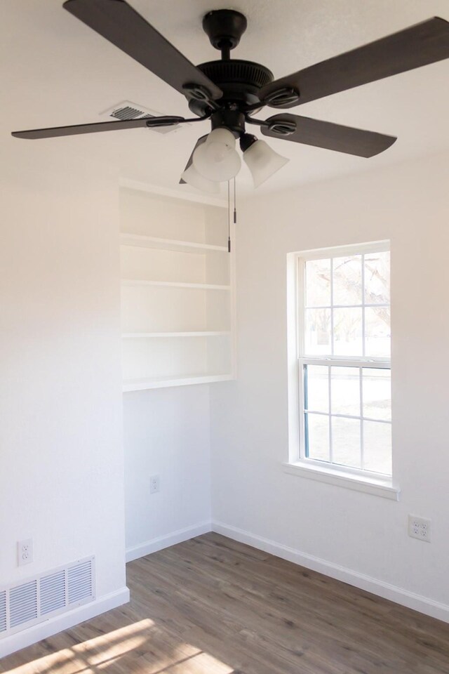 unfurnished room featuring ceiling fan and dark wood-type flooring