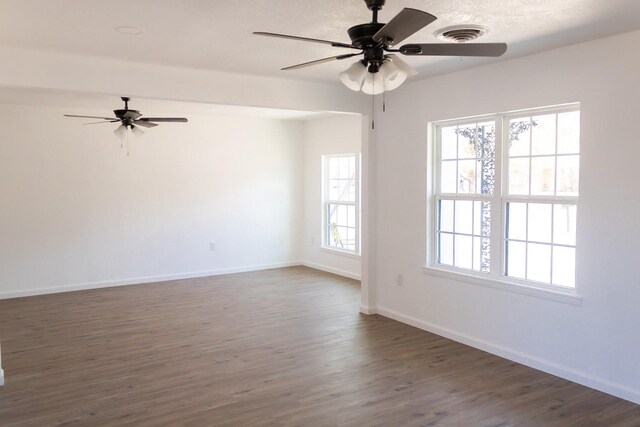 unfurnished room with ceiling fan and dark hardwood / wood-style flooring