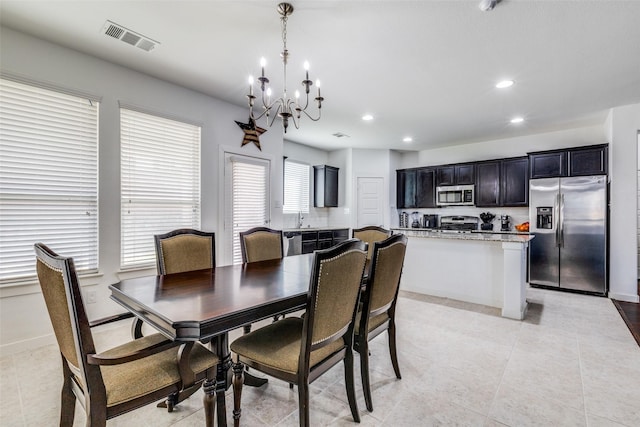 tiled dining room with a notable chandelier, plenty of natural light, and sink