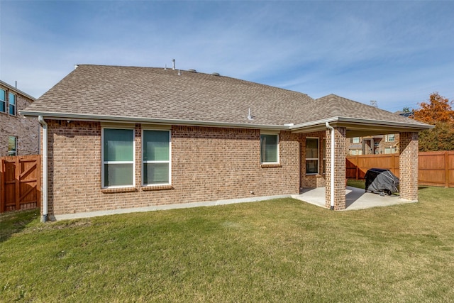 rear view of property featuring a lawn and a patio area