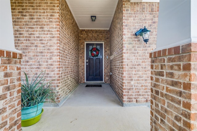 view of exterior entry featuring brick siding