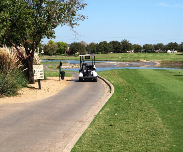 view of property's community with a water view and a lawn