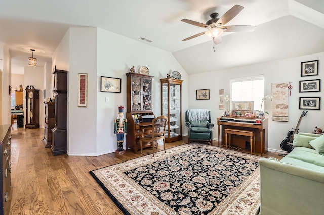 living room featuring ceiling fan, lofted ceiling, and light wood-type flooring