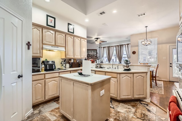 kitchen featuring light brown cabinets, a center island, and sink