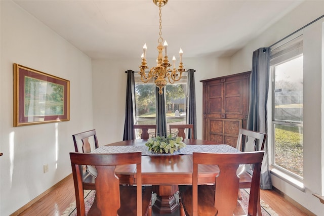 dining space with a chandelier and light hardwood / wood-style floors