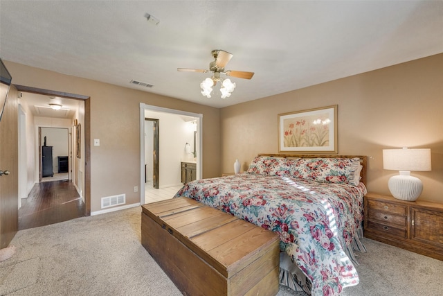 carpeted bedroom with ceiling fan and ensuite bathroom