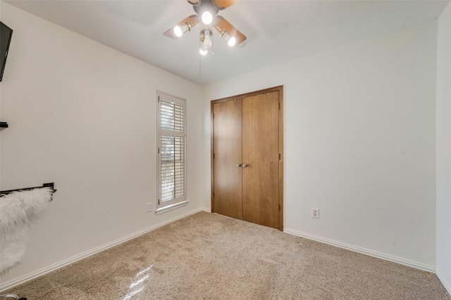 unfurnished bedroom with carpet floors, a closet, and ceiling fan