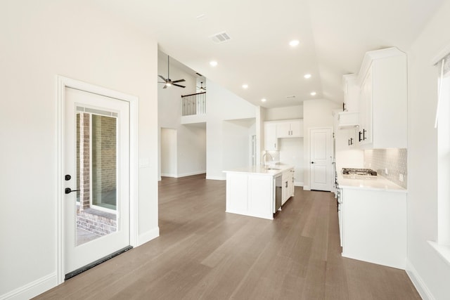 kitchen featuring tasteful backsplash, visible vents, dishwasher, wood finished floors, and white cabinetry