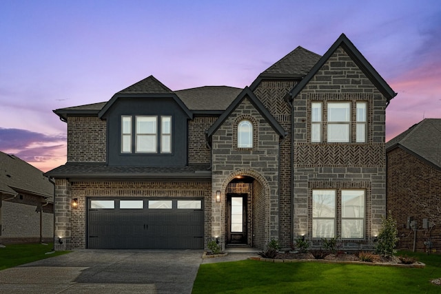 view of front facade featuring a garage, concrete driveway, stone siding, roof with shingles, and brick siding