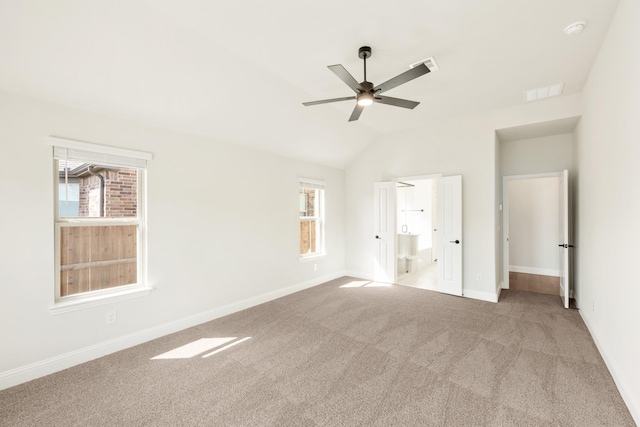 unfurnished bedroom featuring lofted ceiling, multiple windows, visible vents, and carpet flooring