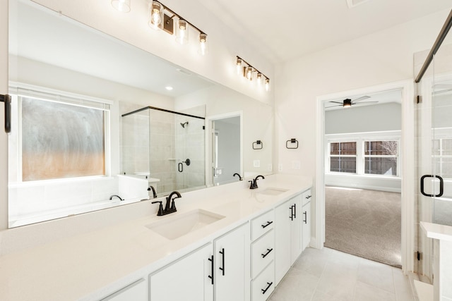 full bath featuring double vanity, tile patterned floors, a sink, and a shower stall