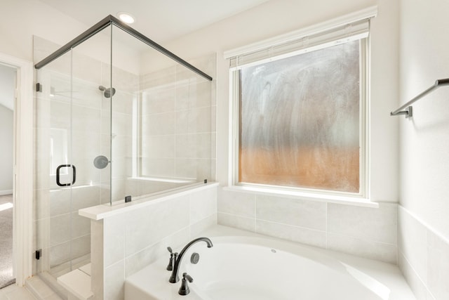 full bathroom featuring a garden tub and a shower stall