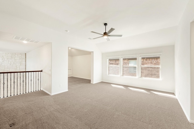 spare room with visible vents, a ceiling fan, carpet flooring, vaulted ceiling, and baseboards