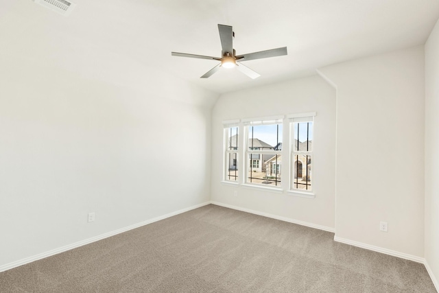 spare room with baseboards, visible vents, a ceiling fan, and light colored carpet