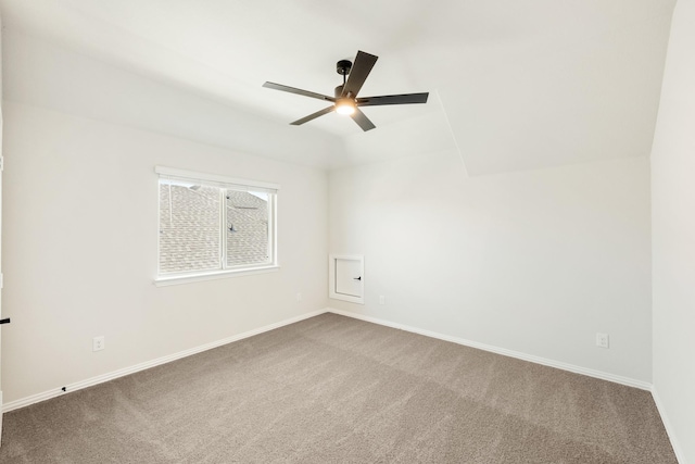 spare room with vaulted ceiling, carpet, a ceiling fan, and baseboards