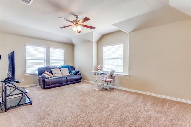 living area featuring light carpet, vaulted ceiling, ceiling fan, and a healthy amount of sunlight