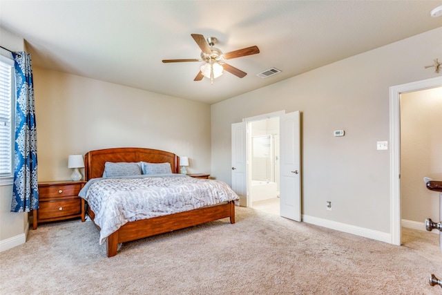 bedroom featuring ensuite bathroom, ceiling fan, and light colored carpet