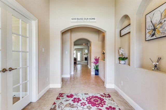 hallway featuring french doors and light tile patterned floors