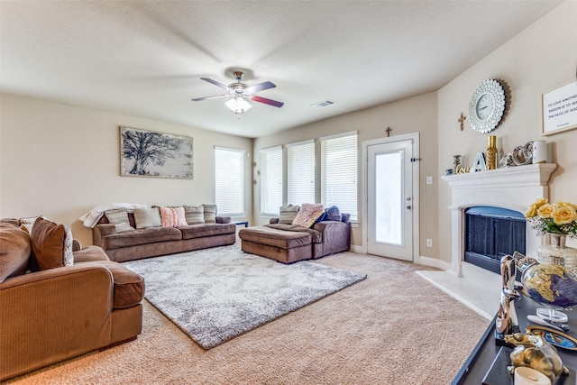 carpeted living room with ceiling fan and a textured ceiling