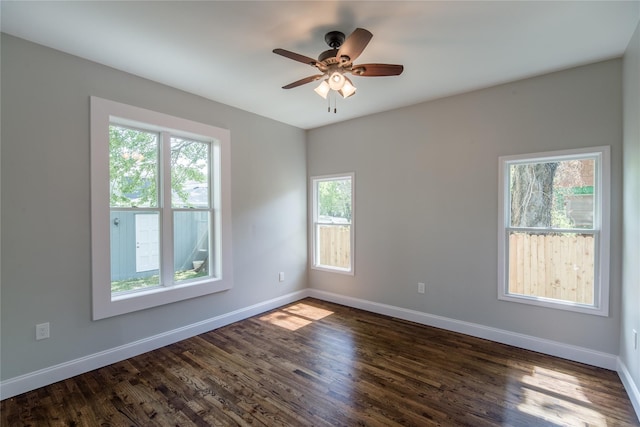 empty room with dark hardwood / wood-style floors and plenty of natural light