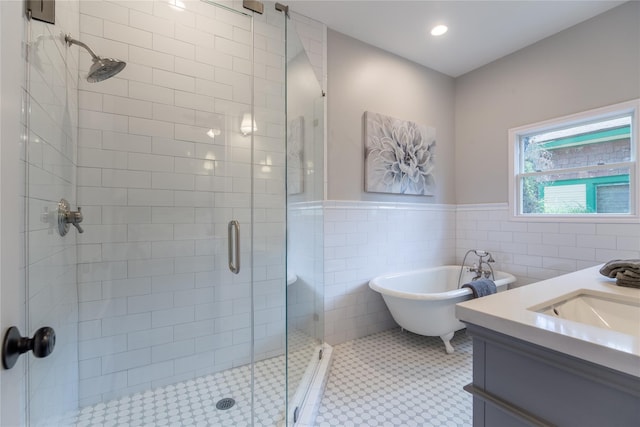 bathroom with shower with separate bathtub, vanity, tile patterned floors, and tile walls