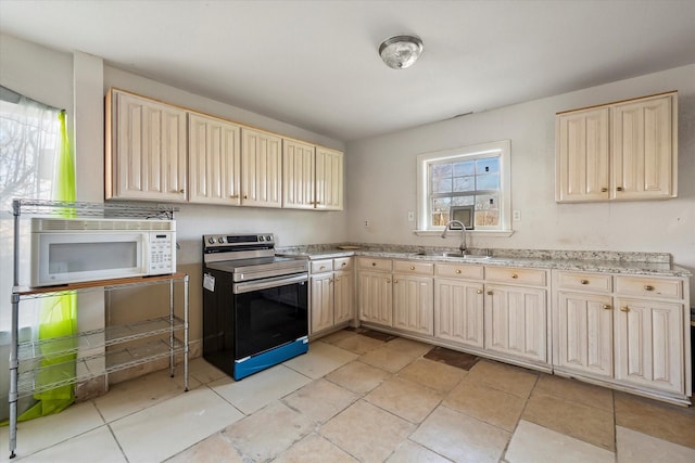 kitchen featuring sink, light stone countertops, and range with electric cooktop