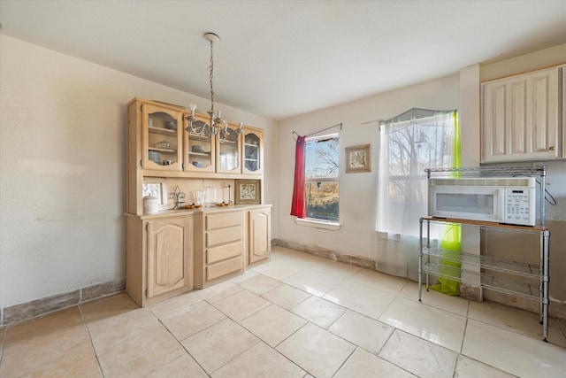 unfurnished dining area with a chandelier and light tile patterned floors