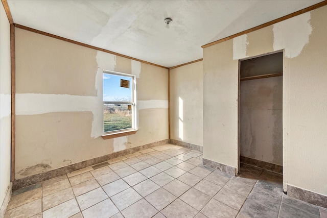 unfurnished bedroom with crown molding and a closet