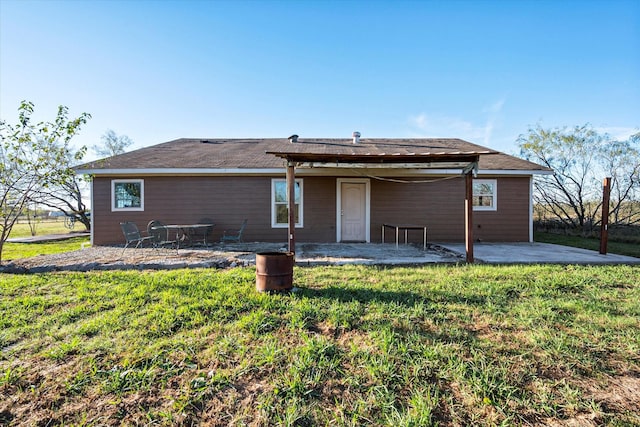 back of property with a yard and a patio area