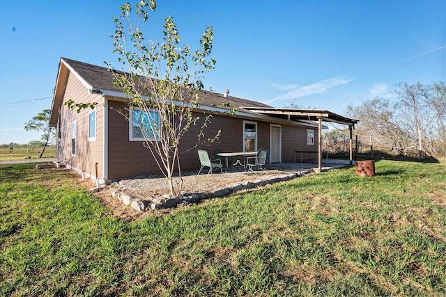 rear view of house with a patio area and a lawn