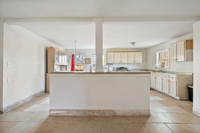 kitchen with a center island, light tile patterned flooring, pendant lighting, and cream cabinetry