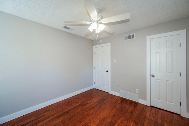 unfurnished bedroom with a textured ceiling, ceiling fan, and dark wood-type flooring