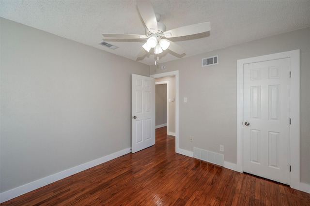 unfurnished bedroom featuring a textured ceiling, ceiling fan, and dark wood-type flooring