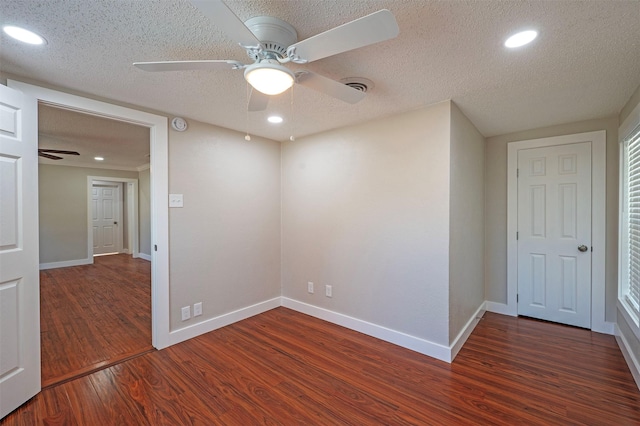 spare room featuring ceiling fan, dark hardwood / wood-style flooring, and a textured ceiling