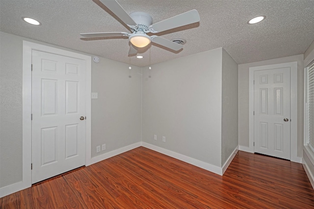 unfurnished room with a textured ceiling, dark hardwood / wood-style floors, and ceiling fan