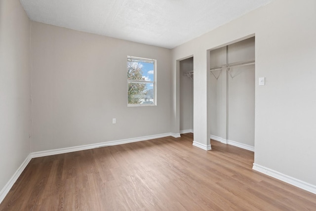 unfurnished bedroom with light hardwood / wood-style flooring and a textured ceiling