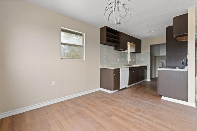 kitchen featuring dishwasher, sink, decorative backsplash, an inviting chandelier, and light hardwood / wood-style flooring