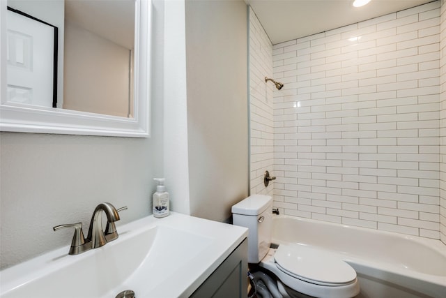 full bathroom featuring vanity, tiled shower / bath combo, and toilet