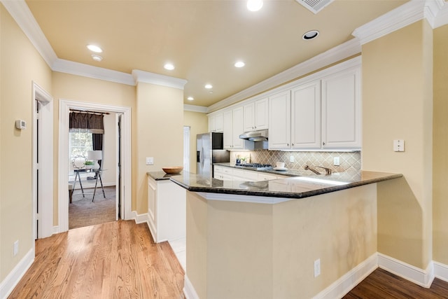 kitchen featuring kitchen peninsula, crown molding, light hardwood / wood-style floors, white cabinets, and appliances with stainless steel finishes