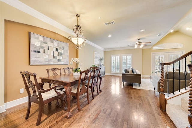 dining room with french doors, ornamental molding, ceiling fan with notable chandelier, hardwood / wood-style floors, and lofted ceiling