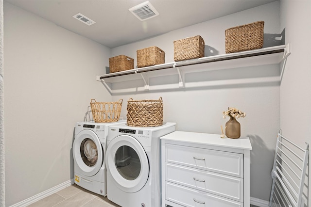 clothes washing area with washer and dryer and light tile patterned floors