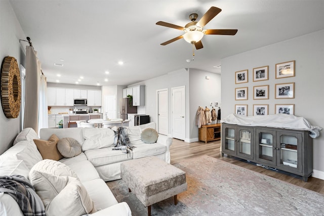 living room with light wood-type flooring and ceiling fan