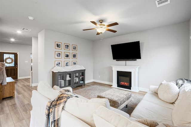 living room featuring light hardwood / wood-style floors and ceiling fan