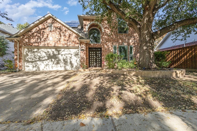 front of property with a garage and solar panels