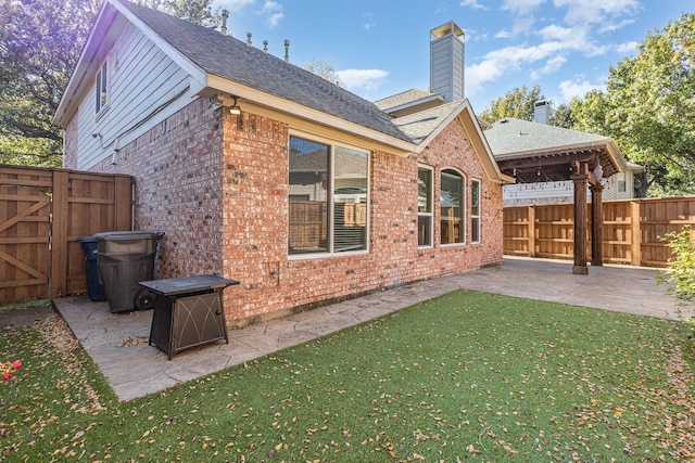 rear view of property featuring a lawn and a patio area