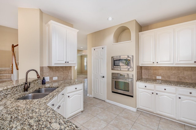 kitchen featuring white cabinets, decorative backsplash, sink, and appliances with stainless steel finishes