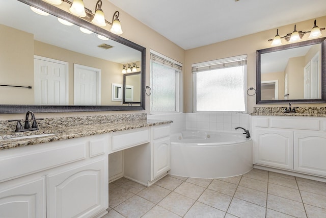 bathroom with tile patterned floors, a washtub, and vanity